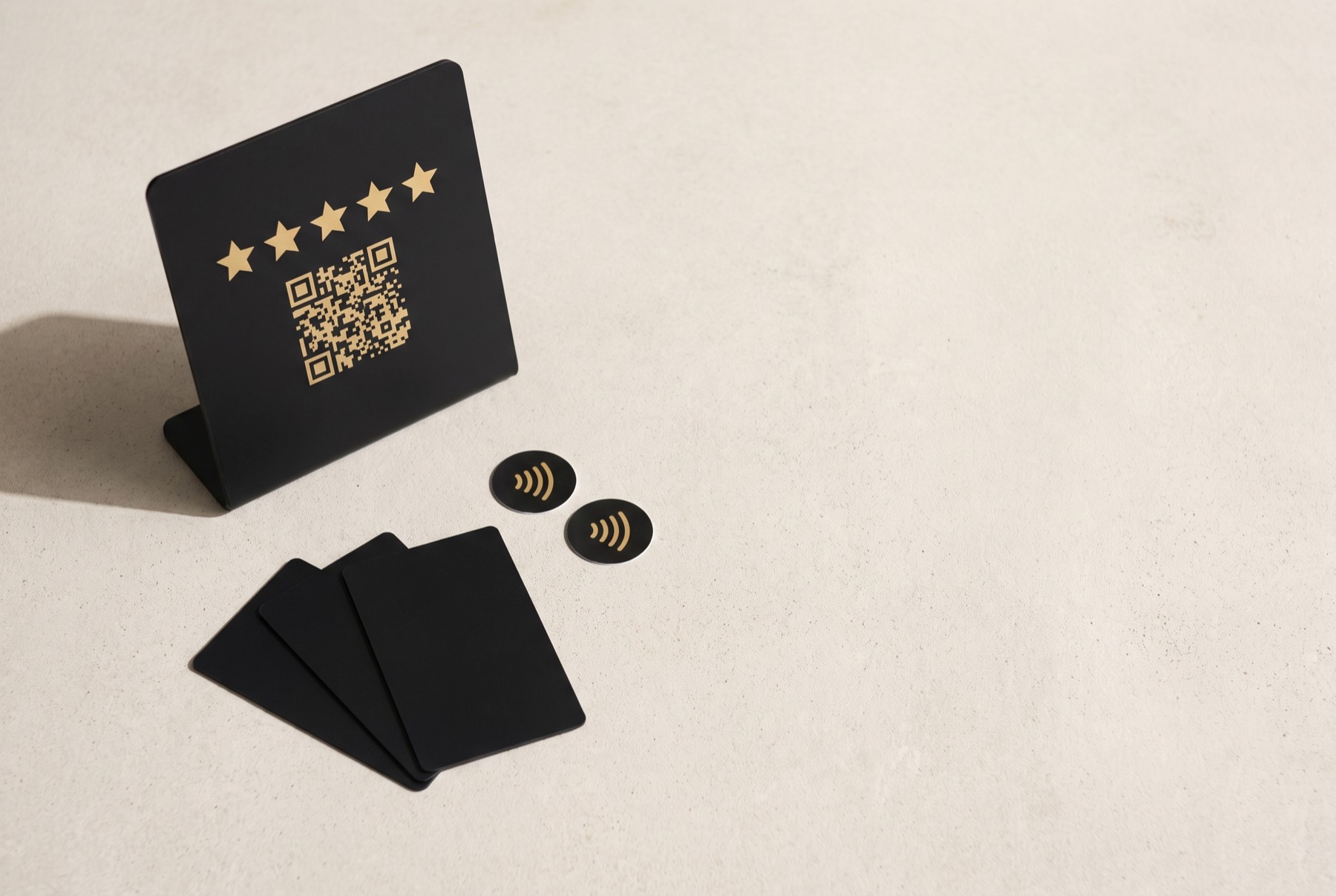 Espositore, card NFC e adesivi disposti su un piano chiaro